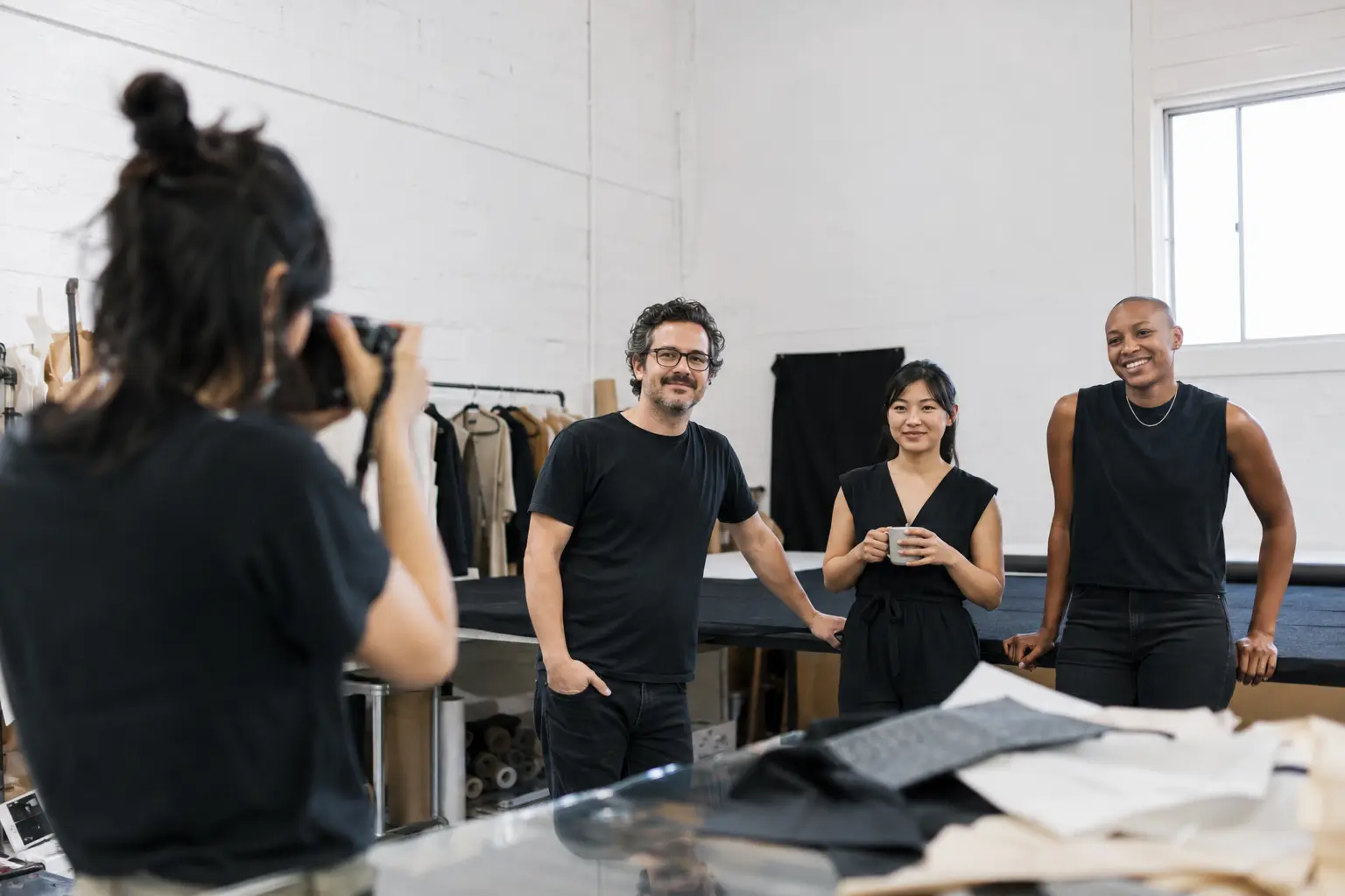 A smiling creative team taking time for a photograph in their studio